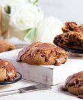 Cinnamon chocolate chip scones with cinnamon glaze on a white surface with a blurred background