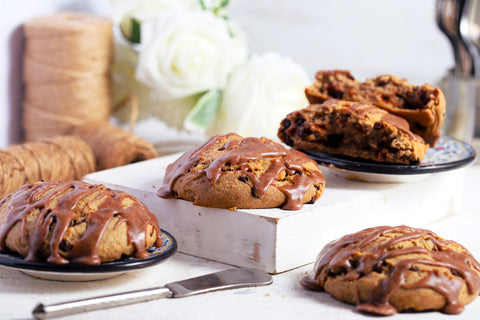 Cinnamon chocolate chip scones with cinnamon glaze on a white surface with a blurred background
