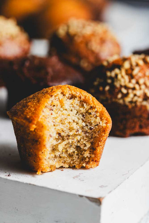 A close up of a mini muffin cut open with more mini muffins in the background