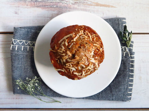 Single harvest muffin on a white plate with a gray cloth napkin.