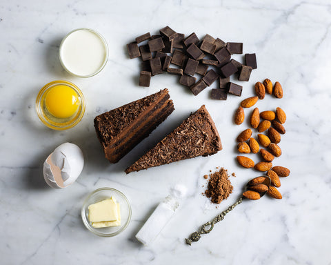 Two Slices of Low-Sugar Gluten-Free Chocolate Keto Cake On Marble Table with Chocolate Pieces and Almonds
