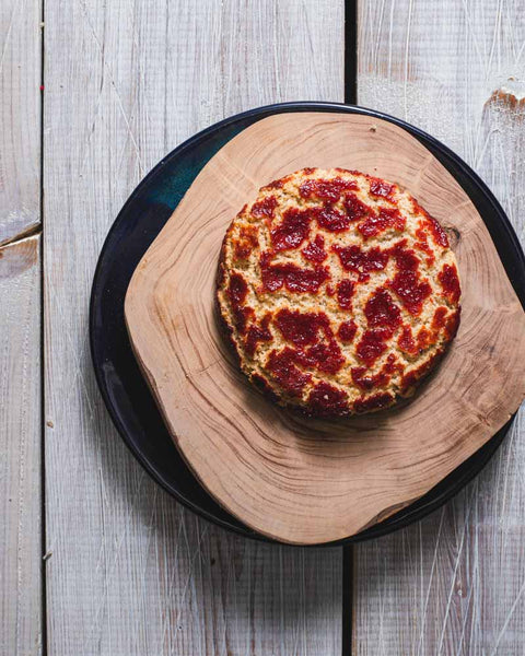 Raspberry crinkle cookie with a crackled top, displayed on a wooden board.