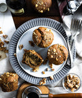 Top view of vegan and gluten-free banana walnut muffins on a decorative plate surrounded by scattered walnuts.