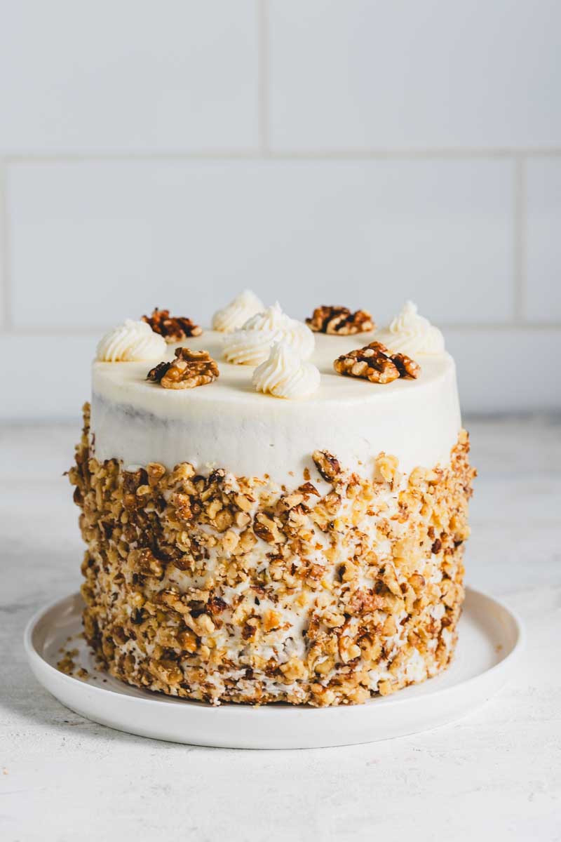 Banana walnut cake with vanilla icing and crushed walnut decoration