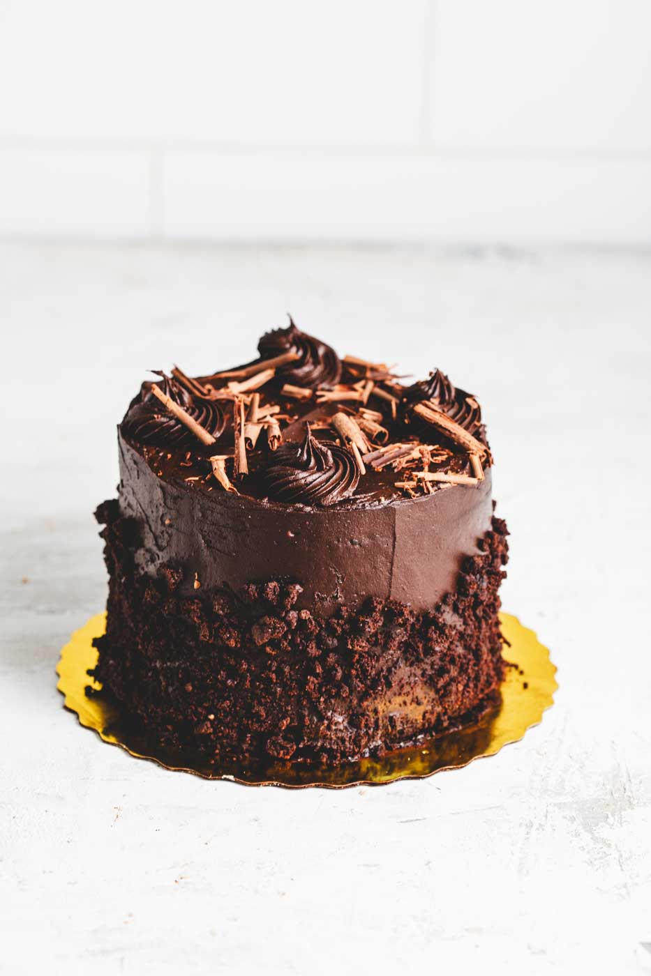 chocolate fudge cake with rich chocolate frosting rolled in chocolate crumbs with chocolate shaving garnish