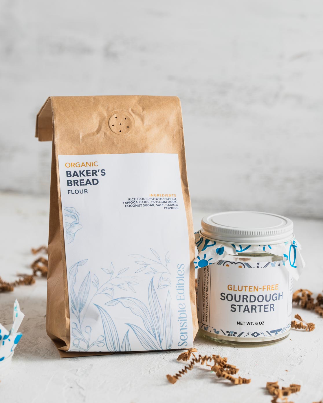 Bag of organic baker's bread flour next to a jar of gluten-free sourdough starter.