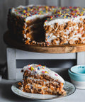 Vegan & Gluten-Free Vanilla Birthday Cake with Sprinkles and a Slice taken out.