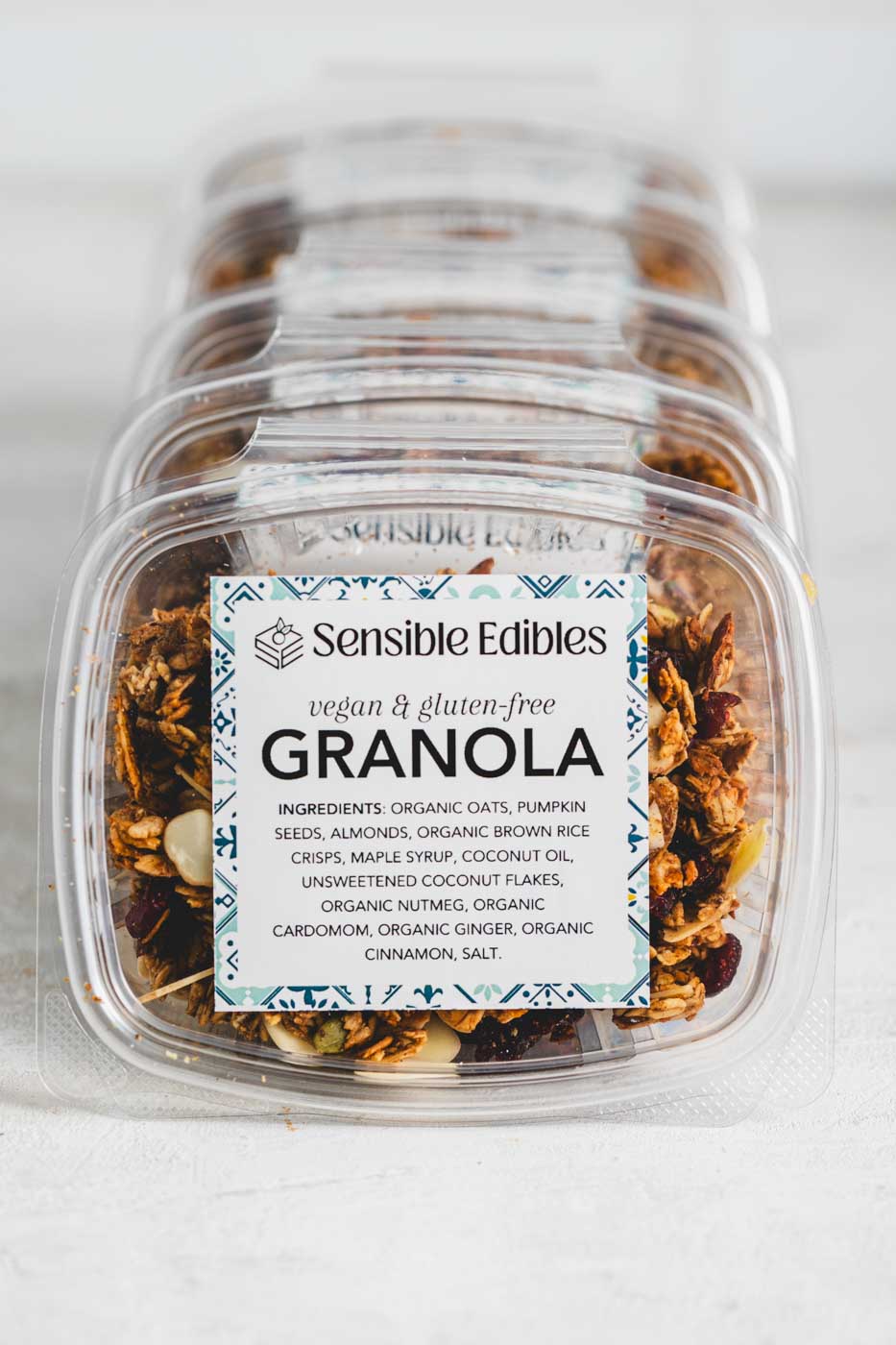 Lined up boxes of granola with oats, pumpkin seeds, almonds, and cranberries