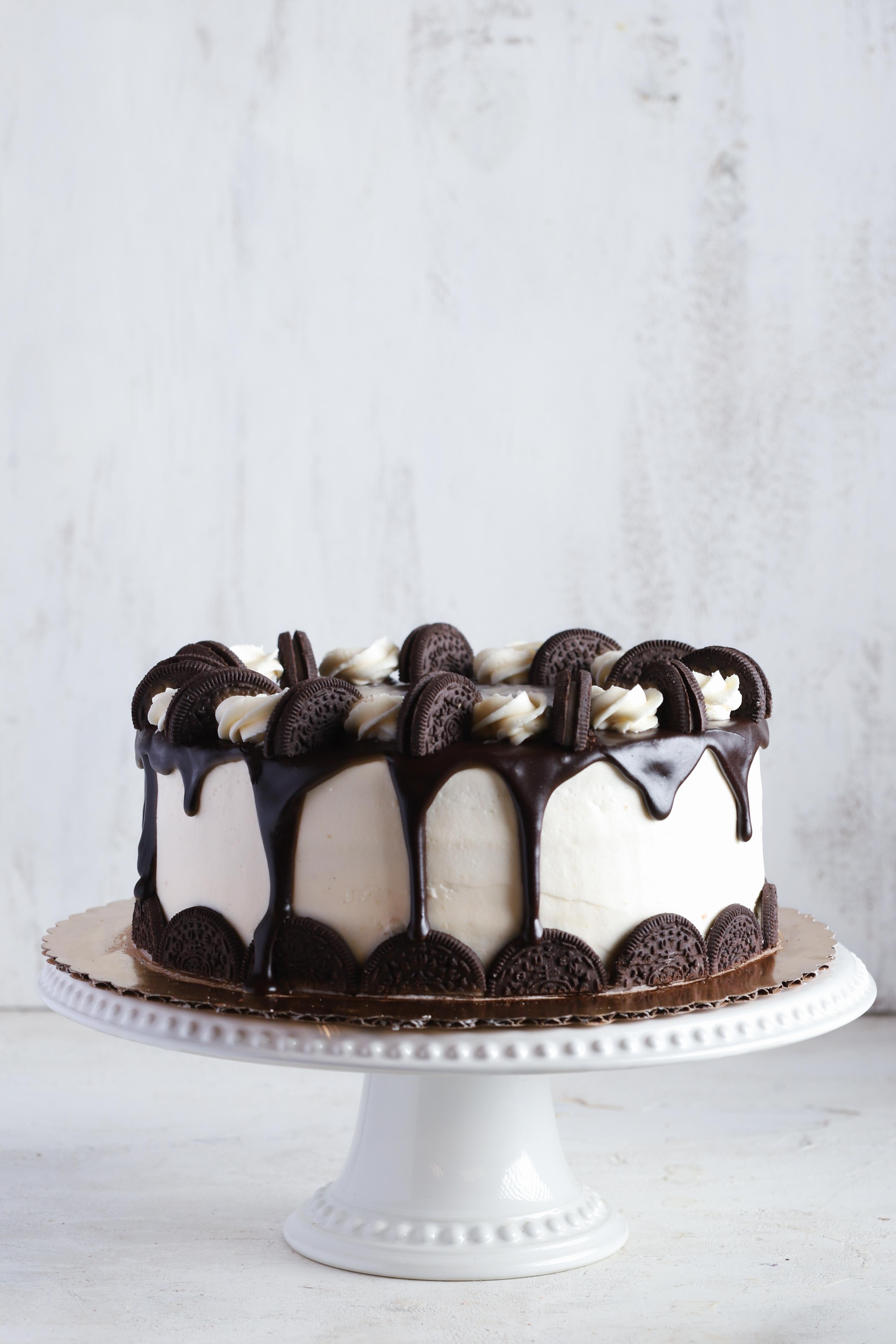 Cookies and cream cake with vanilla and chocolate frosting decorated with oreo cookies on a white background
