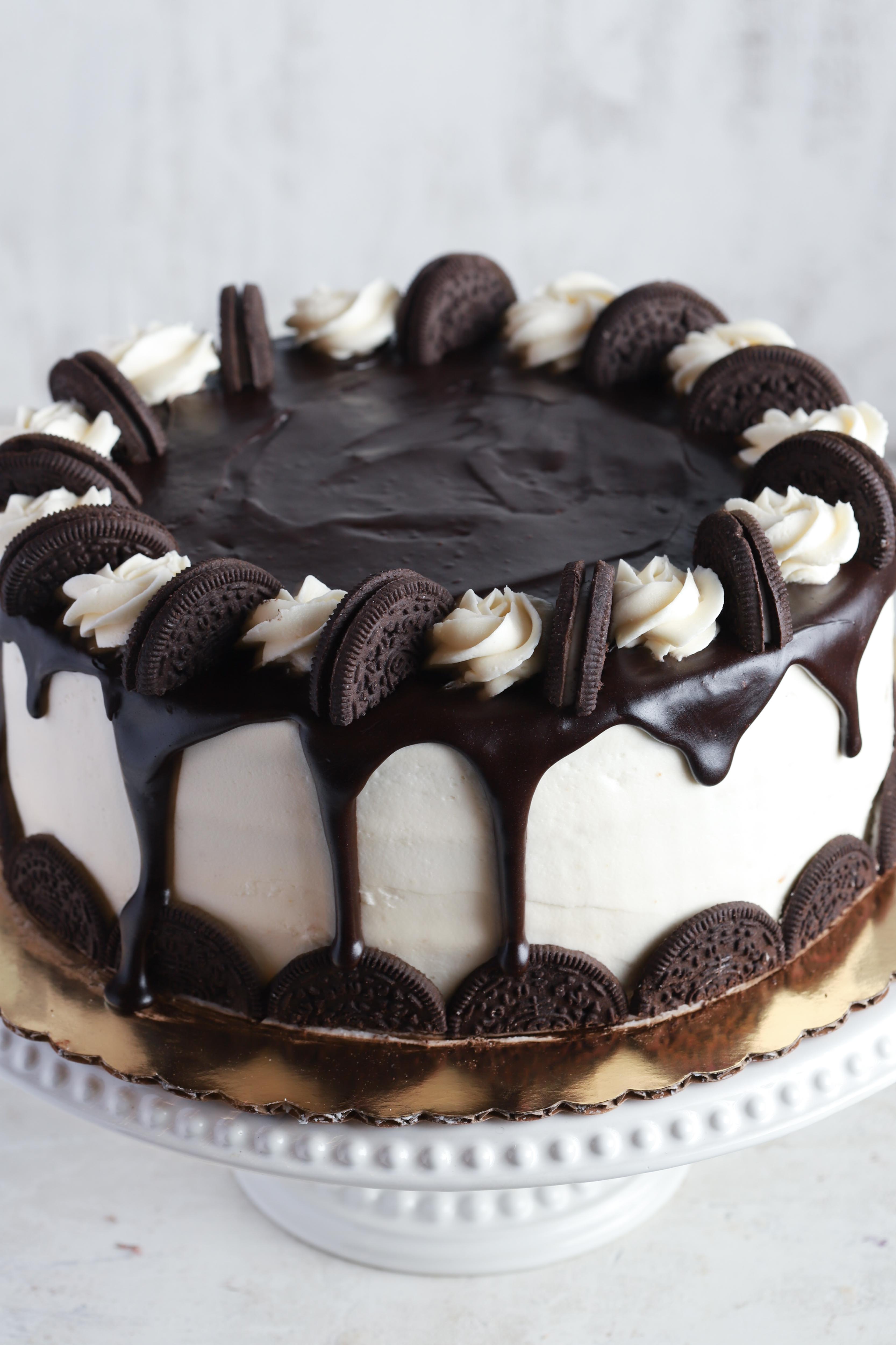 Cookies and cream cake with vanilla and chocolate frosting decorated with oreo cookies on a white background
