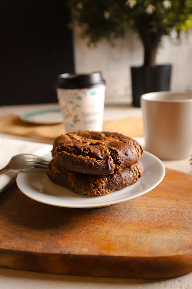 Chocolate chia cookies on a plate with a coffee cup in the background