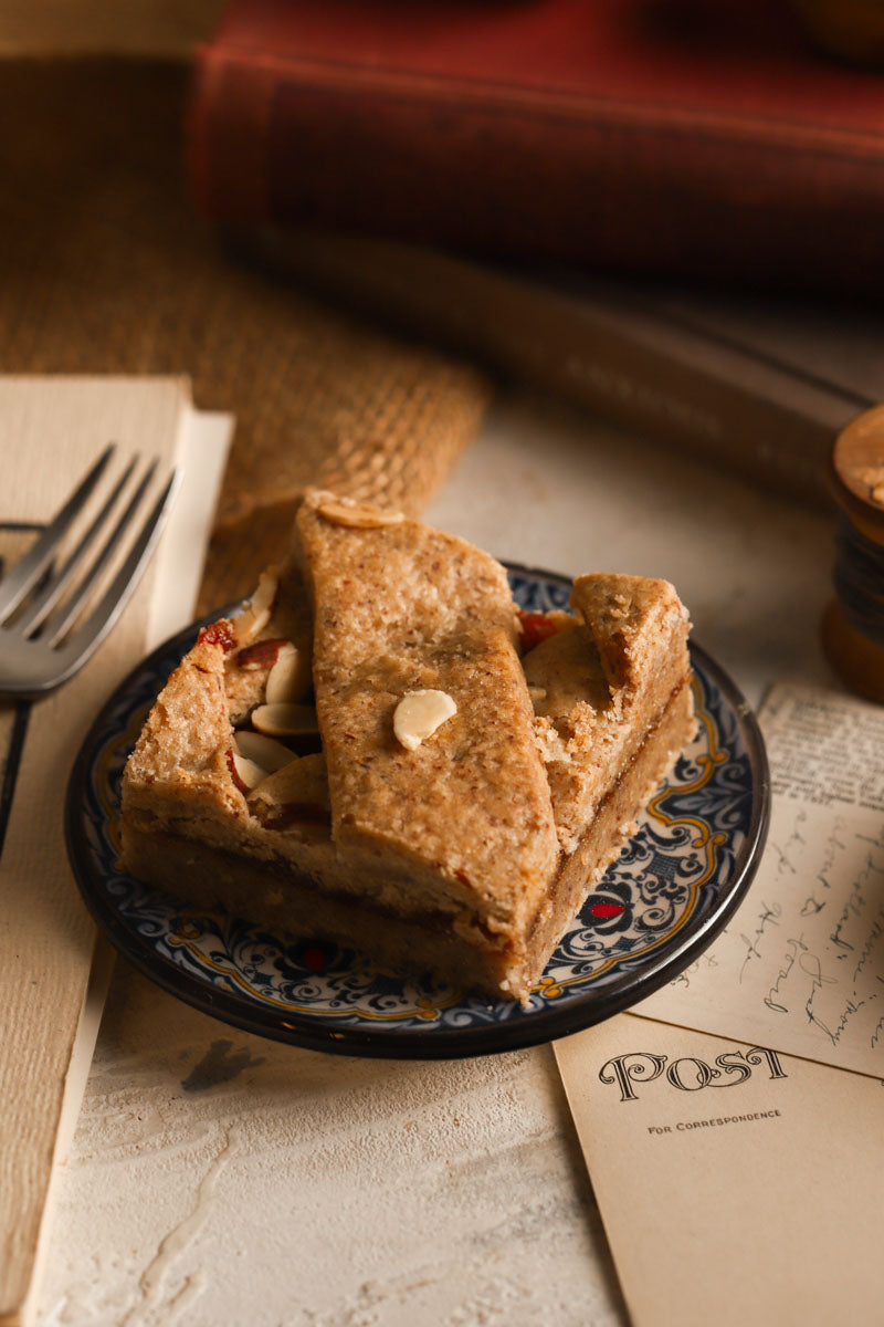 Raspberrry hazelnut bars on a plate with a warm, rustic background