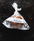 3 Vegan & Gluten-Free Banana Walnut Muffins in packaging on black background