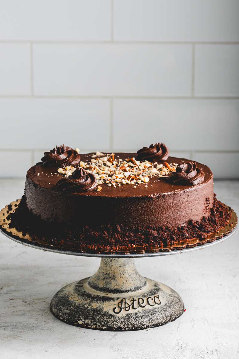 Keto chocolate cake with rich chocolate frosting and chocolate crumble and nut decoration