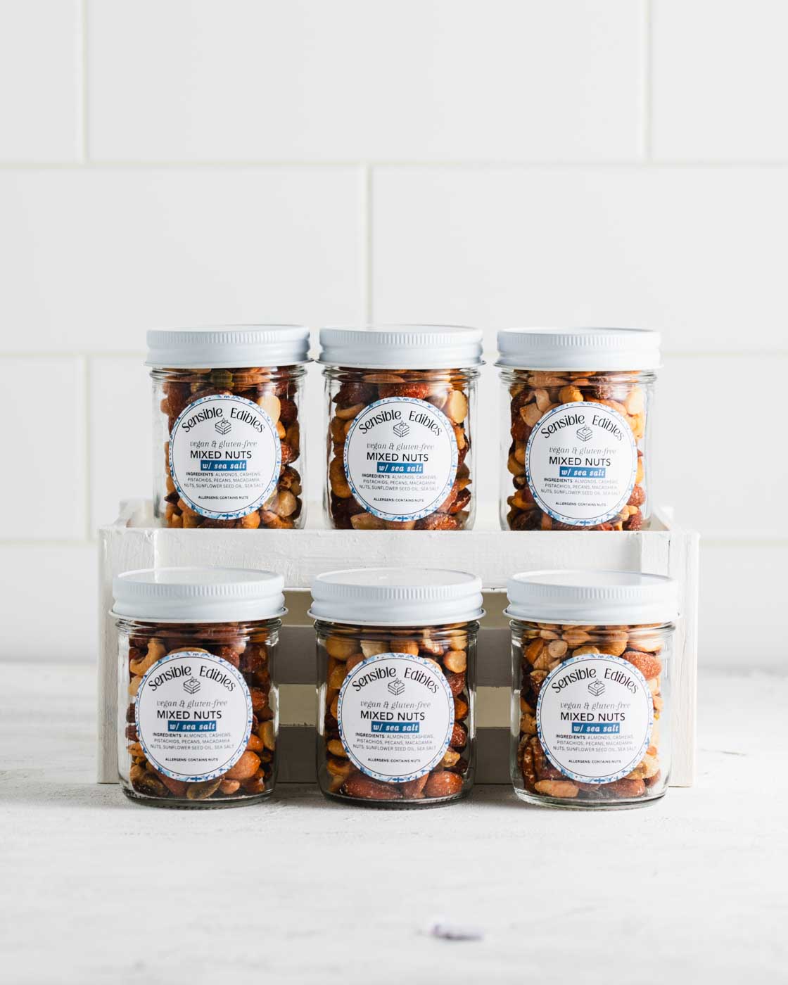 Jars of salted mixed nuts dispalyed in rows across two shelves