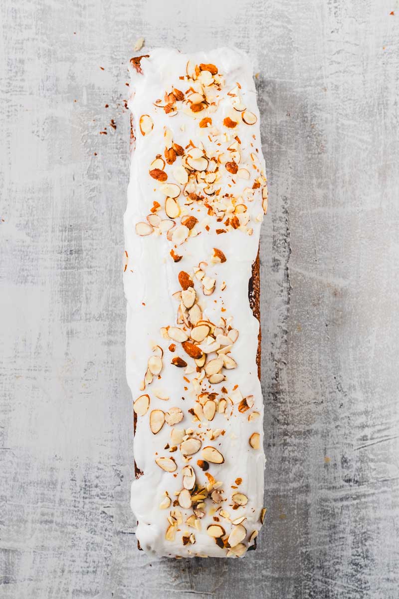 lemon almond loaf with frosting and sliced almonds on top