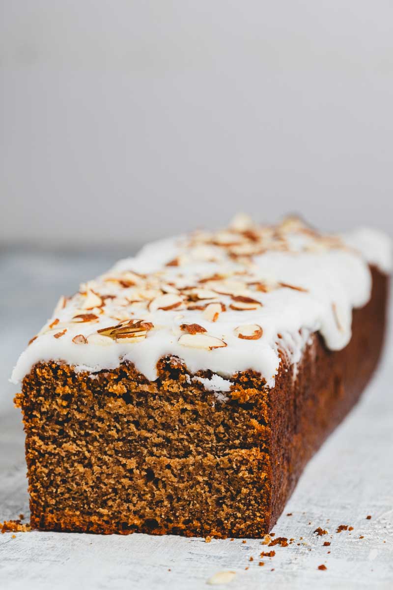 lemon almond loaf with frosting and sliced almonds on top