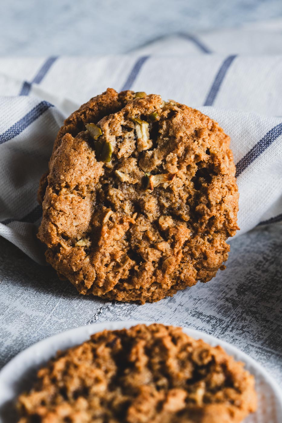 Apple oatmeal cookies stacked against a white cloth
