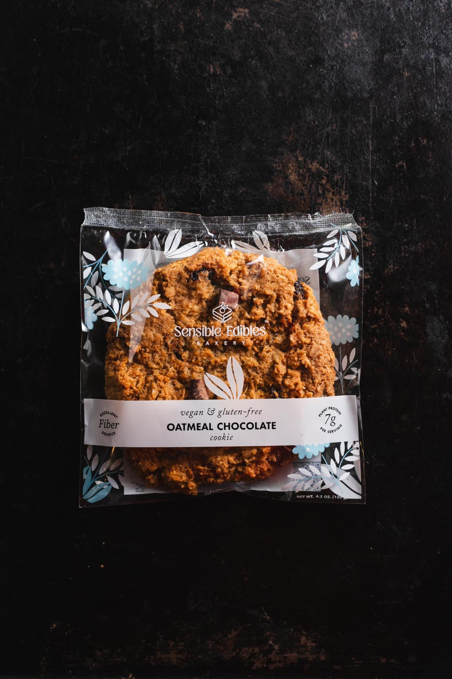Oatmeal chocolate cookie in packaging on a dark background
