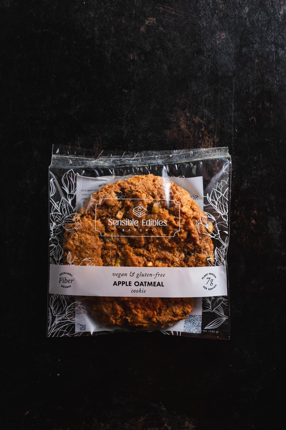Apple oatmeal cookie in packaging on a dark background