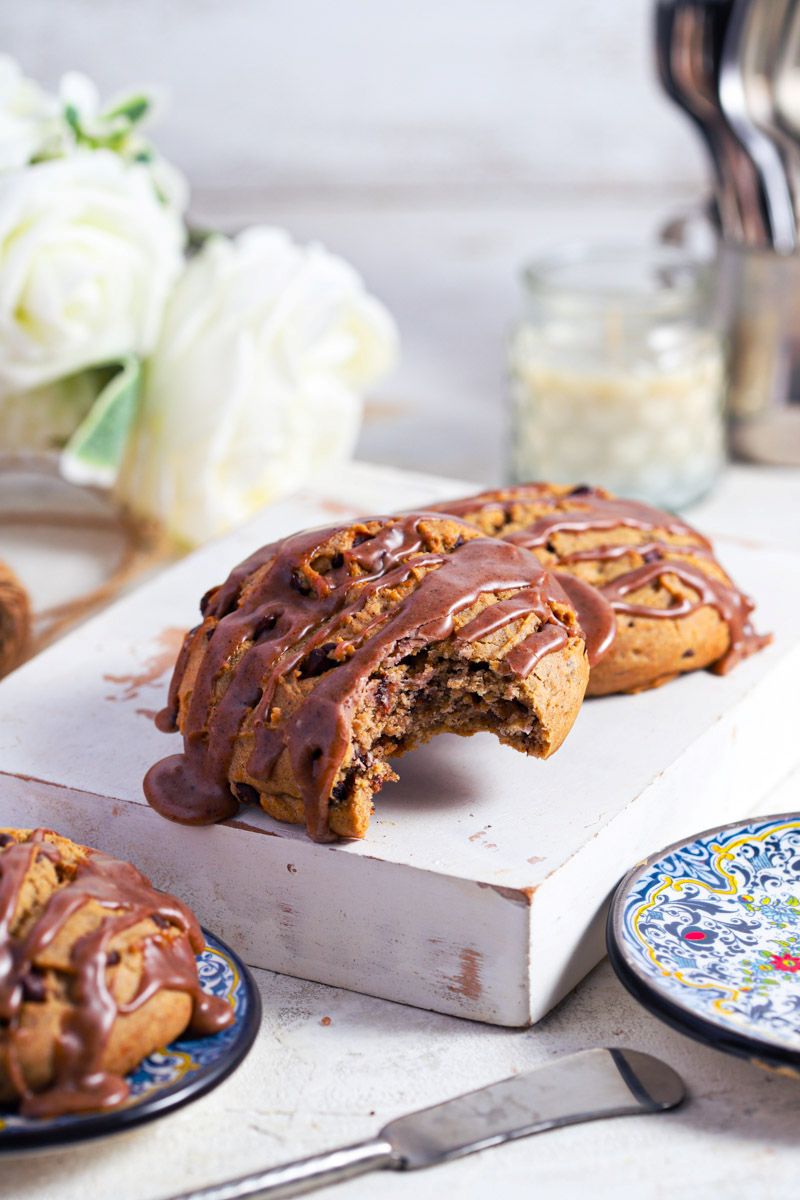 Cinnamon chocolate chip scones with cinnamon glaze on a white background with blue plates
