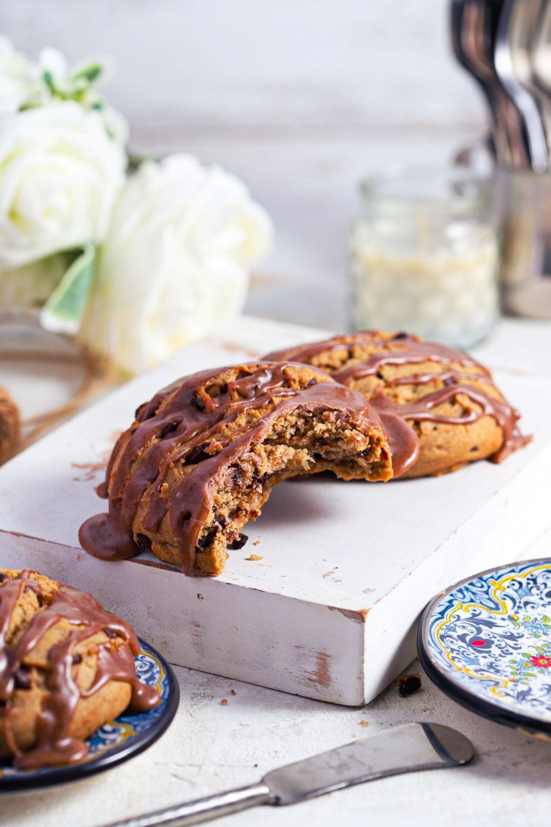 Cinnamon chocolate chip scones with cinnamon glaze on a white background with blue plates