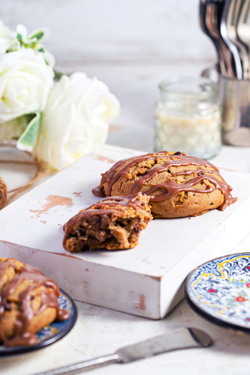 Cinnamon chocolate chip scones with cinnamon glaze on a white background with blue plates
