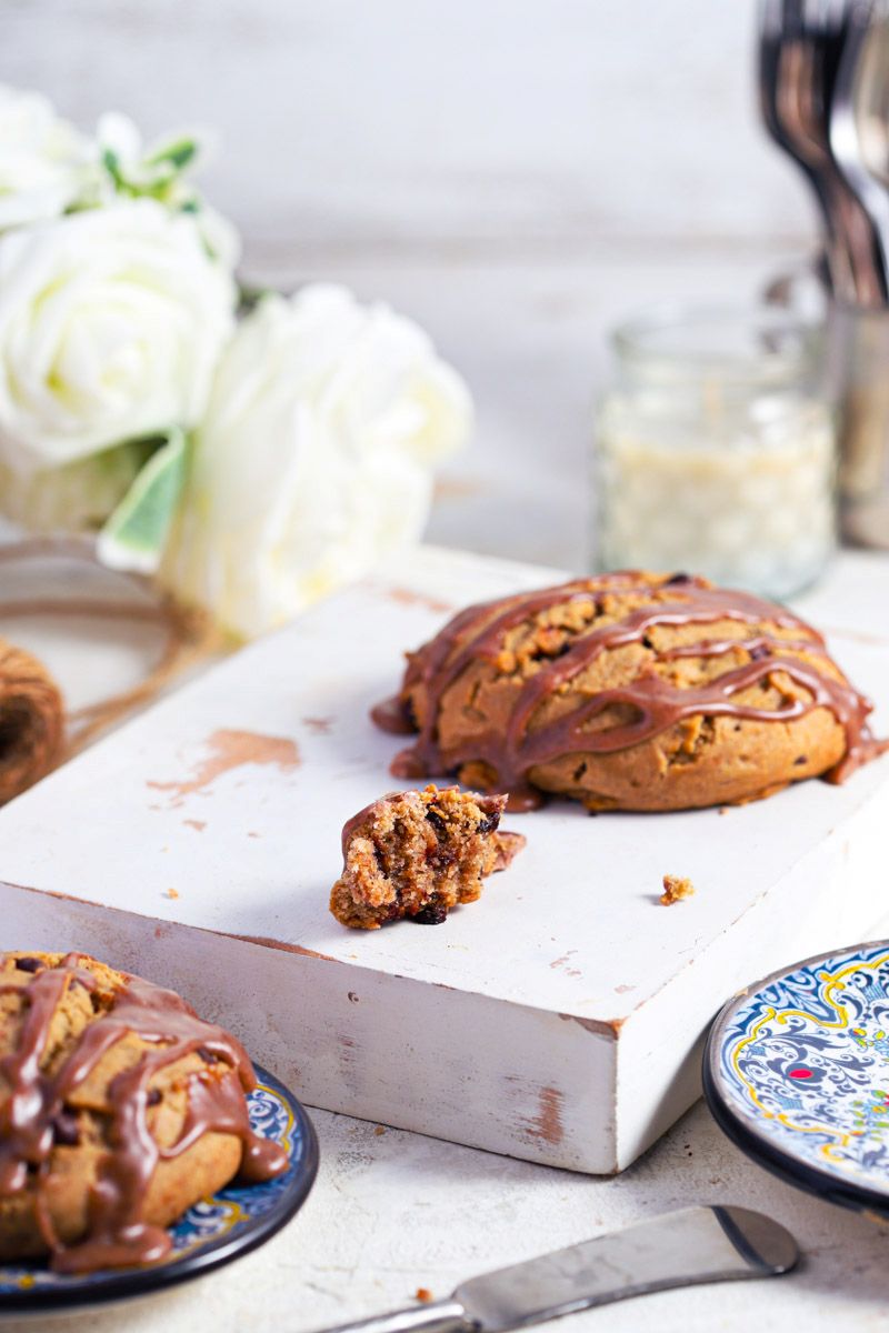 Cinnamon chocolate chip scones with cinnamon glaze on a white background with blue plates