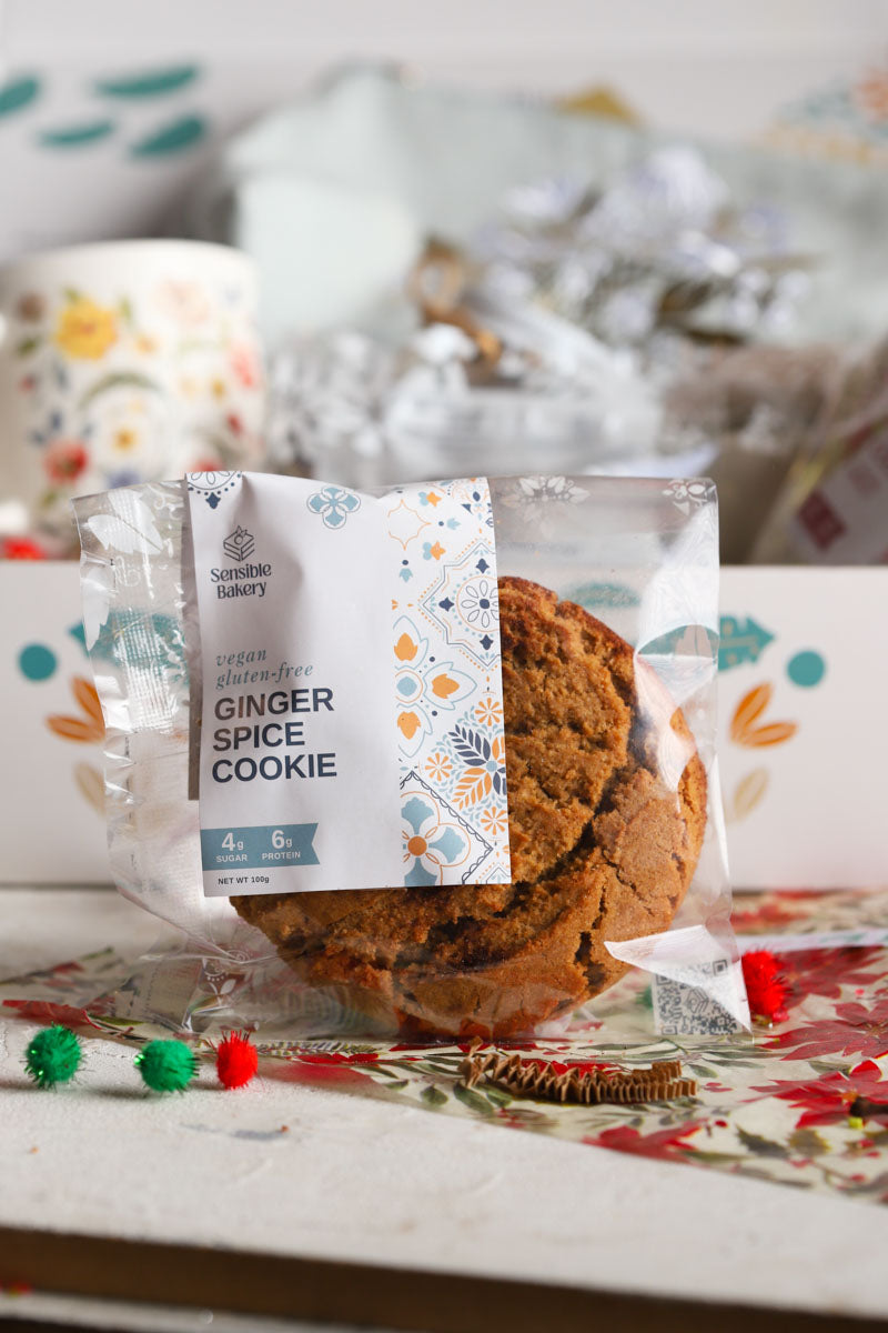 Packaged ginger spice cookie with a decorative label on a patterned surface