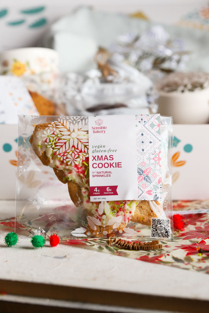 Packaged christmas cookie with decorative label on a patterned surface