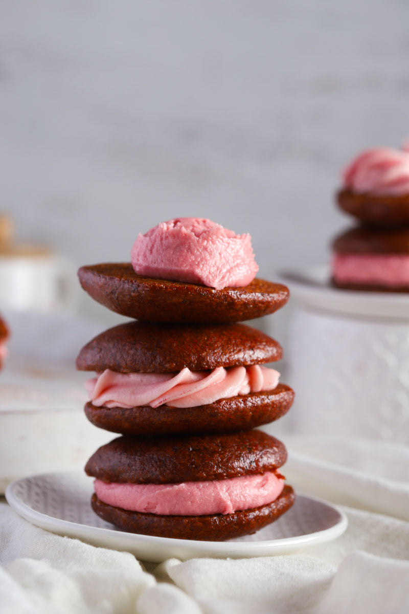 Stack of vegan gluten free red velvet whoopie pies with a white background