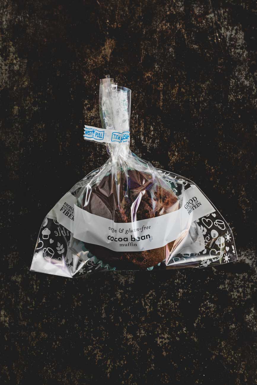 Packaged cocoa bean muffin from Sensible Edibles Bakery, labeled and wrapped in decorative packaging.