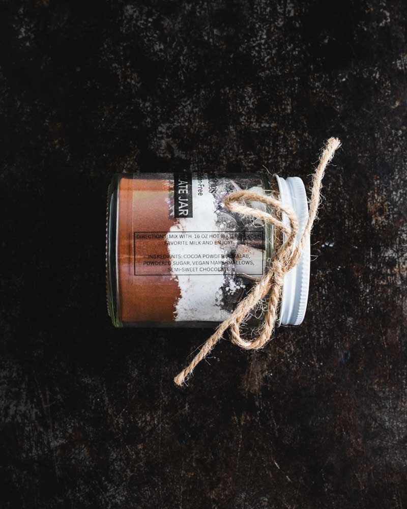Hot chocolate jar on its side, showing the layered ingredients and tied with twine.