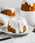 mini lemon pound bundt cakes with glaze on plates with vanilla beans