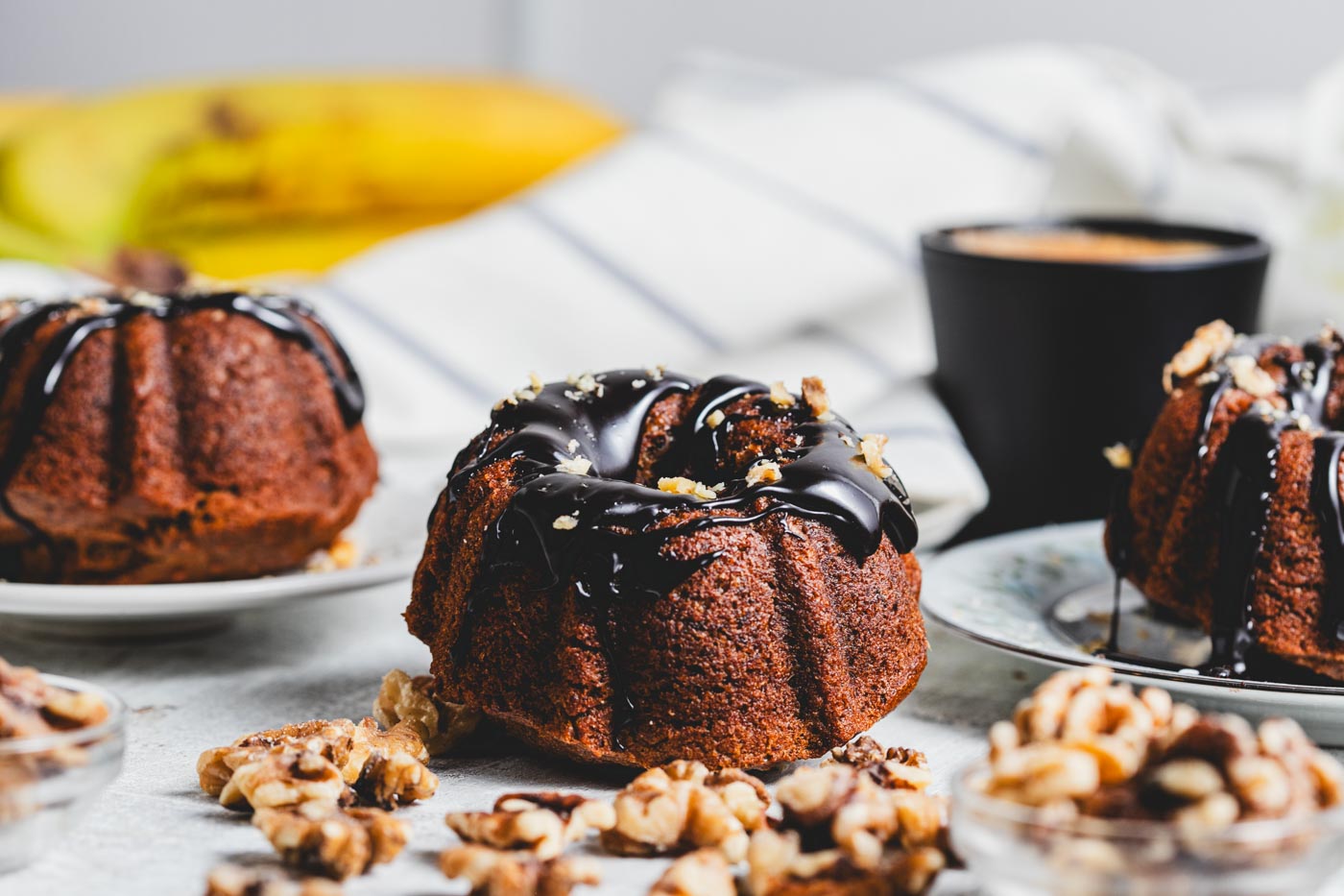 Mini banana bundt cakes with chocolate glaze and crushed walnuts