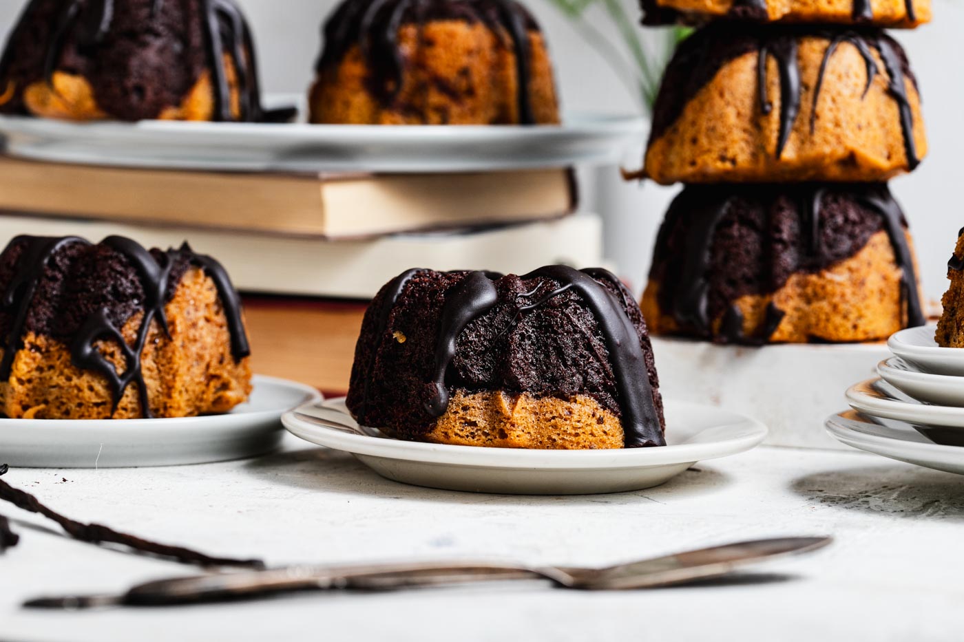 mini marble bundt cakes with chocolate glaze on various plates