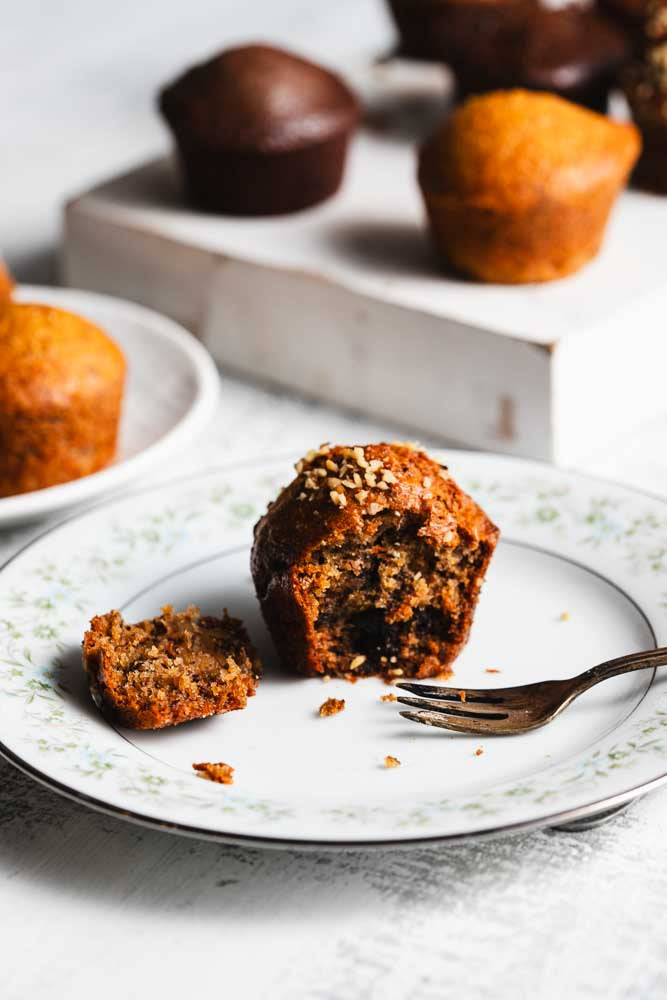a variety of mini muffins on white plates with one cut open in the front