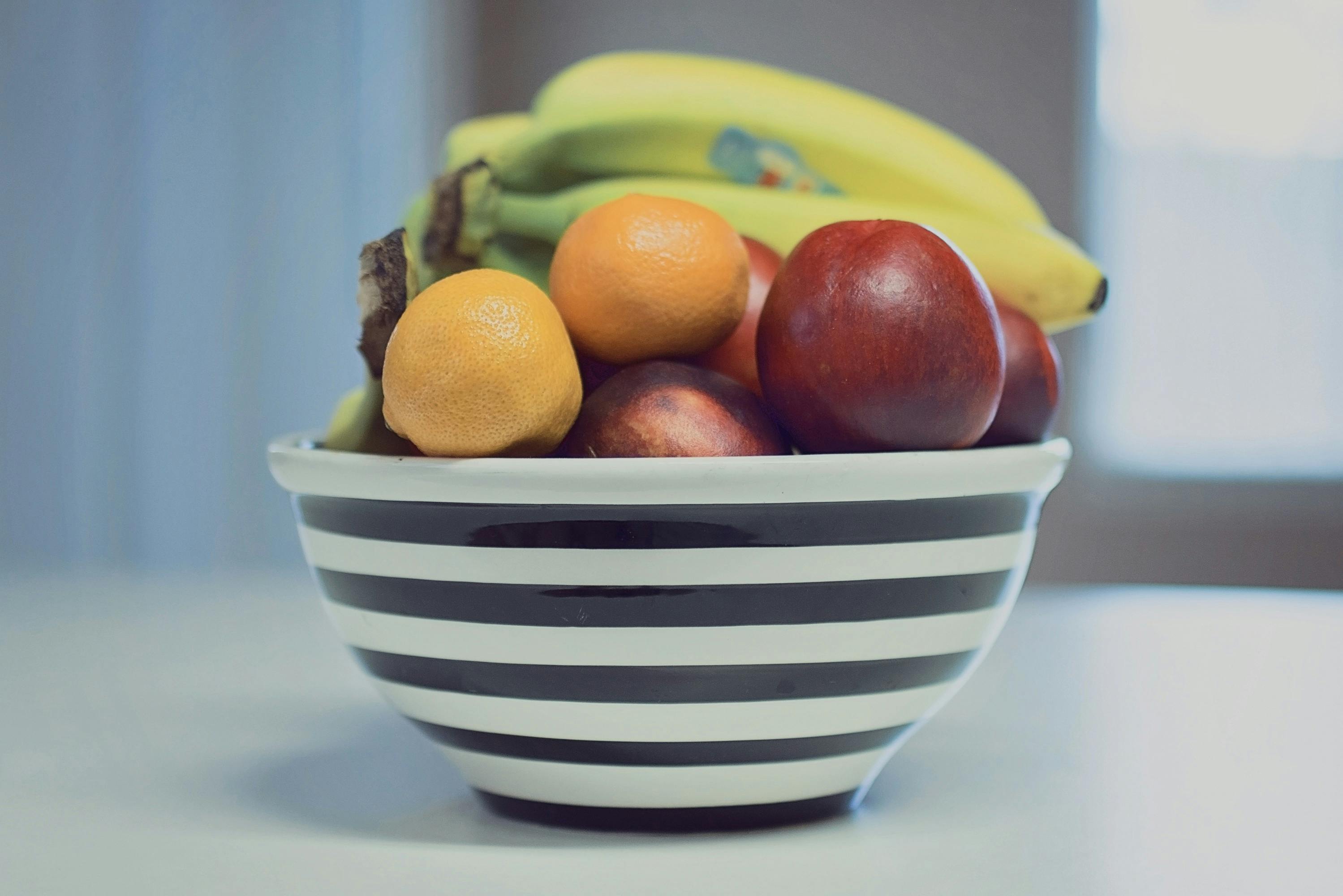 A bowl of fruits on a white counter