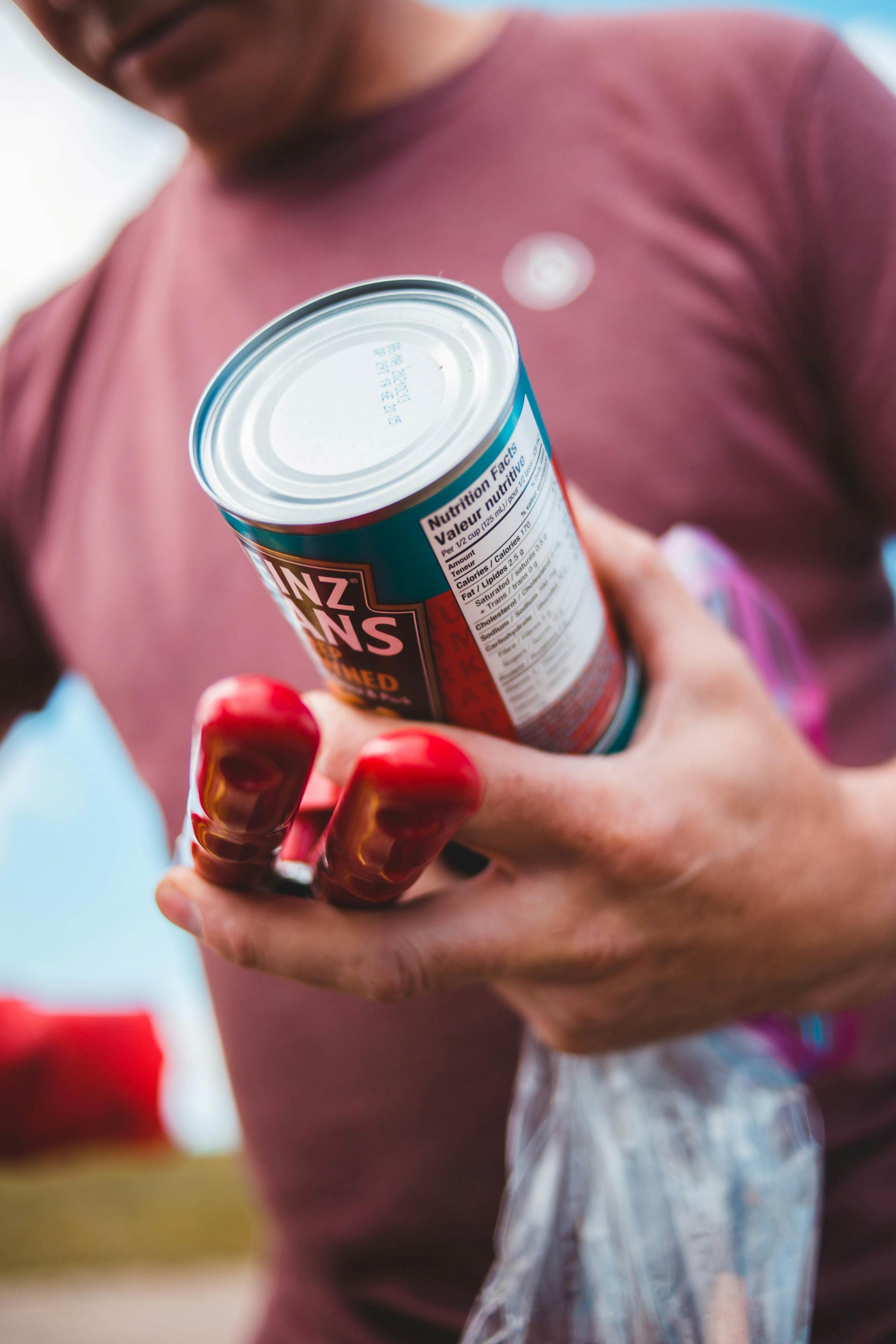 A person holding a can and examening the label with the nutrition facts visible