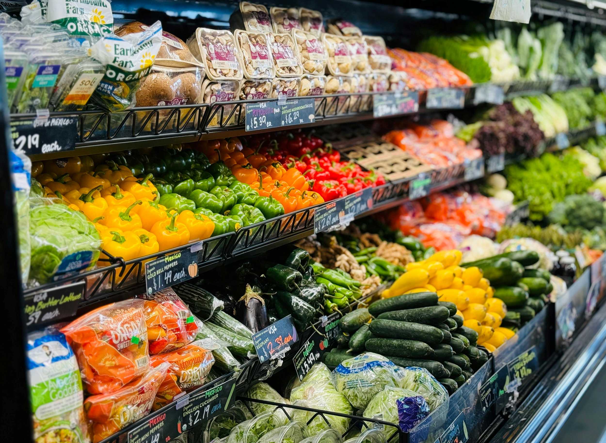 Shelves of vegetables in a grocery store with labels