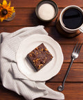 Vegan Gluten-Free Walnut Brownie on White Plate with Fork and Cup of Coffee on Wooden Table